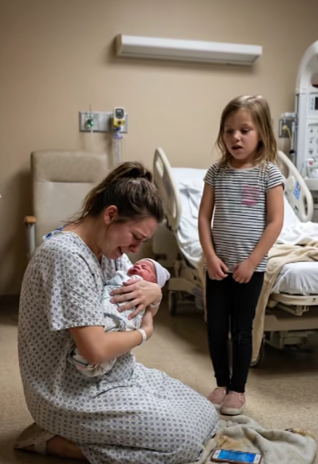 My 10-year-old stared at the newborn and softly said, “Mom… we can’t bring this baby home.” Confused, I asked her why. Her hands trembled as she handed me her phone. “You need to see this,” she said. The second I looked at the screen, my knees almost gave way.